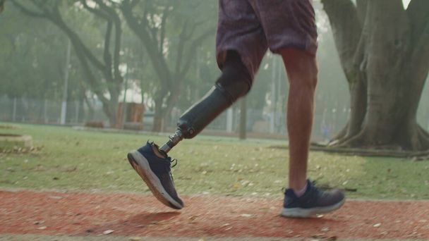 Atleta discapacitado corriendo con pierna protésica en pista de atletismo. Corredor motivacional del atleta amputado - Foto, imagen