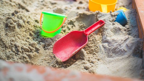 Children plastic toys in the sand box. Shovel, selective focus. - Fotó, kép