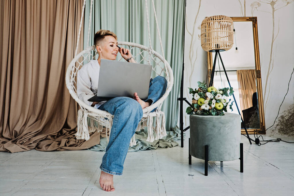 Блогер-хипстер, работающая с ноутбуком в студии. Modern Girl creator with laptop at Home office. Блогер моды работает в офисе с ноутбуком - Фото, изображение