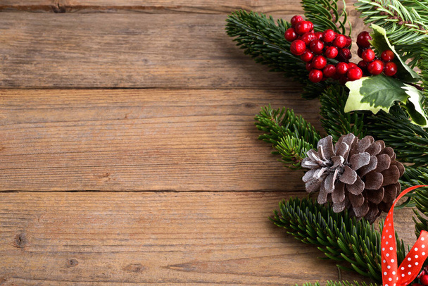 Рождественская елка украшения рамки на деревенском деревянном фоне. Рождественский фон с еловыми ветвями, красными ягодами, конусами, плоским слоем и копировальным пространством, элемент дизайна - Фото, изображение
