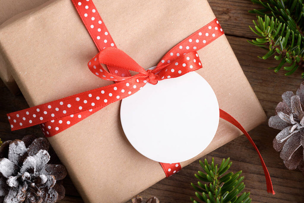 Blank okrągły świąteczny prezent tag makieta z pudełka, makieta etykieta produktu, z naturalną gałązką jodły, szyszki i dekoracja świąteczna, koncepcja sprzedaży świątecznej - Zdjęcie, obraz