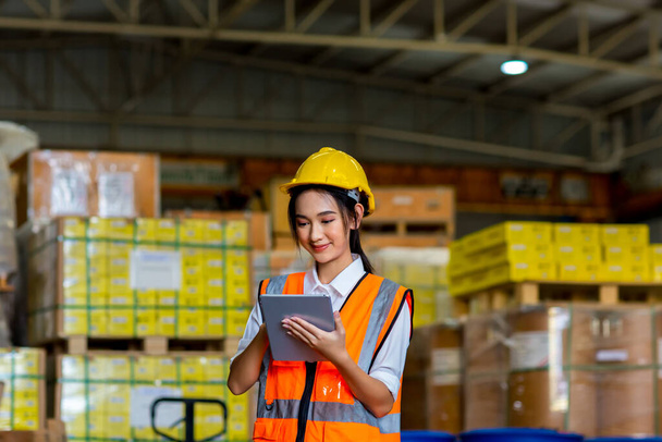 Woman worker working in warehouse. Industrial and industrial workers concept. worker woman order details and checking goods and Supplies. - Foto, immagini