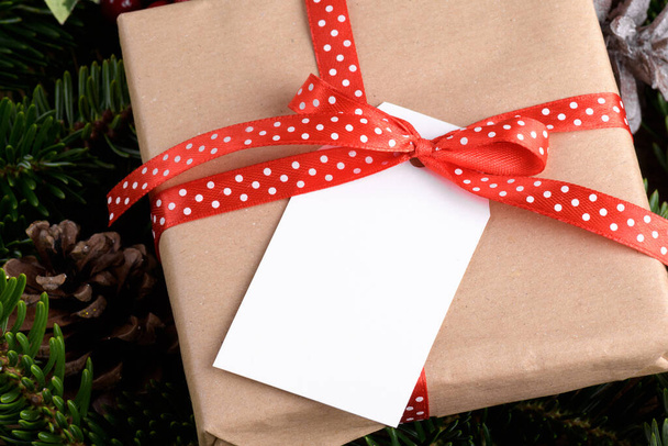 Рождественский прямоугольник подарочный макет с подарочной коробкой, макет этикетки продукта, с натуральной елкой ветки, конусы и рождественское украшение, рождественская концепция распродажи. Чистый бумажный прямоугольный бейдж - Фото, изображение