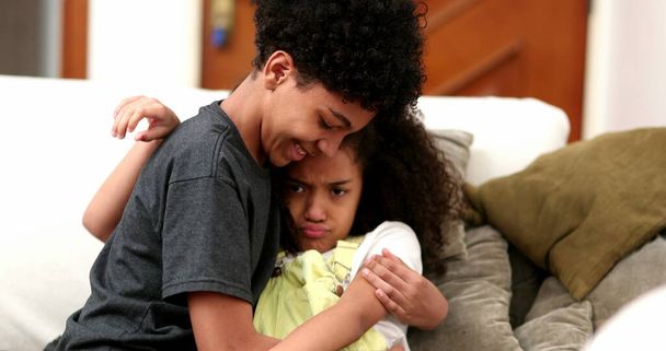 Brother trying to console upset little sister. mixed race black ethnicity - Photo, image