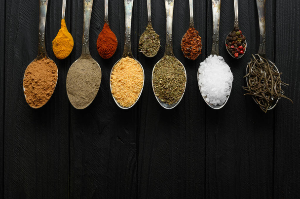 Colorful various herbs and spices for cooking on dark wooden rustic background - Fotó, kép