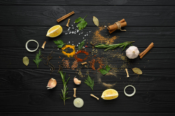 Colorful various herbs and spices for cooking on dark wooden rustic background - Photo, Image