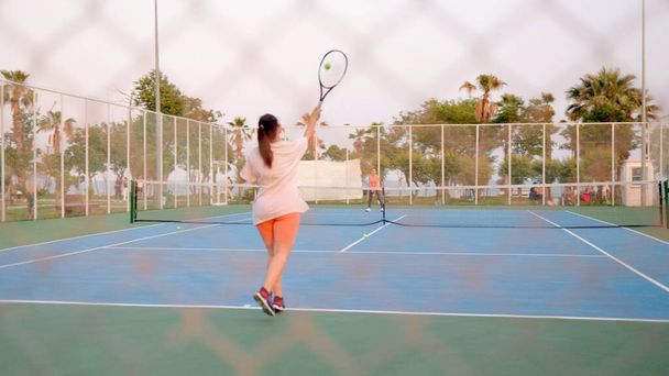 Tennisspieler schlägt den Ball mit einem Schläger von hinten. Zeitlupe. Hochwertiges 4k Filmmaterial - Foto, Bild