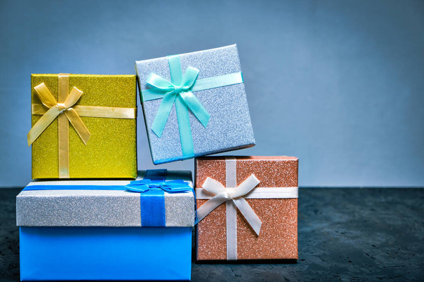 Multi colored gift boxes with bows different colors gray background - Foto, immagini