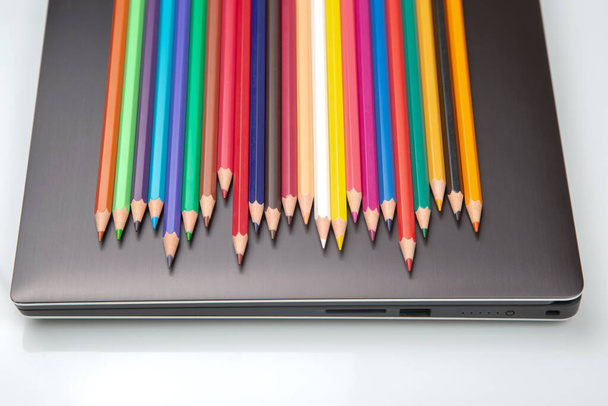 colored pencils on the background of a laptop - Fotoğraf, Görsel