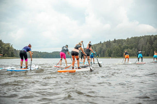 Vaidava, Latvia - 01.08.2021: A lot of People paddle with SUP stand up paddle board. SUP competition, race. awesome active outdoor recreation. - Fotoğraf, Görsel