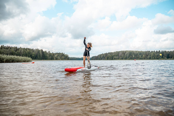 Вайдава, Латвия - 01.08.2021: SUP stand up paddle boarding. Конкурс SUP, гонка. потрясающий активный отдых на свежем воздухе.  - Фото, изображение