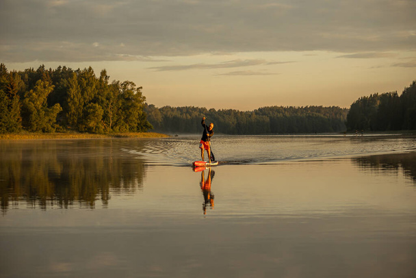 Vaidava, Latvia - 01.08.2021: SUP stand up paddle boarding. SUP competition, race. awesome active outdoor recreation.  - Foto, immagini