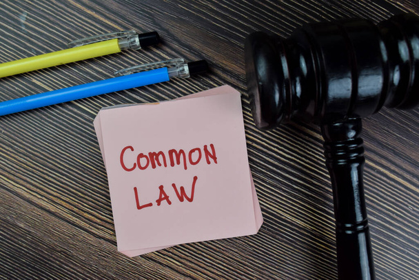 Concept of Common Law write on sticky notes isolated on Wooden Table. - Foto, afbeelding