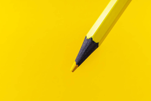 Buntstift-Nahaufnahme mit selektivem Fokus auf den Stift und einem verschwommenen gelben Hintergrund. Kopierraum für Text. - Foto, Bild