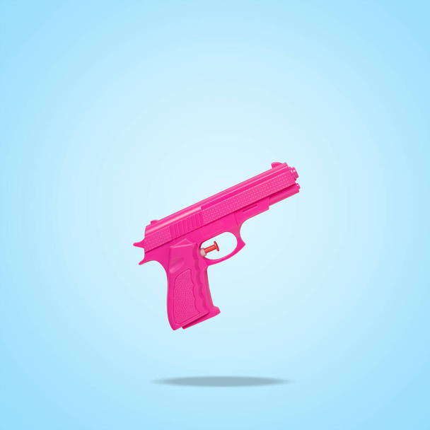Pink handgun on bright blue background. Minimal creative concept. - Фото, зображення
