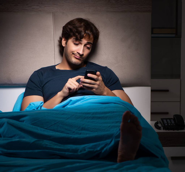 Le jeune homme texter sur mobile tard dans la nuit - Photo, image