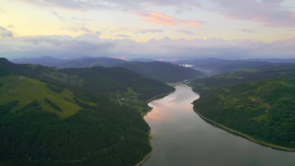 Aerial drone view of nature in the Carpathians in Romania at sunset. Lake Izvorul Muntelui located in a valley, hills covered with lush forest - Séquence, vidéo