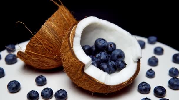 The blueberry inside of halves of coconut. Juicy berries. - Video