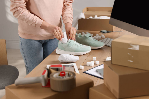 Seller packing shoes at workplace, closeup. Online store - Fotó, kép