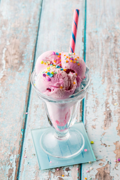 A delicious cotton candy ice cream sundae topped with sprinkles, ready for eating.  - Zdjęcie, obraz