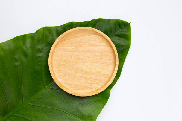 Piatto di legno su foglie verdi - Foto, immagini