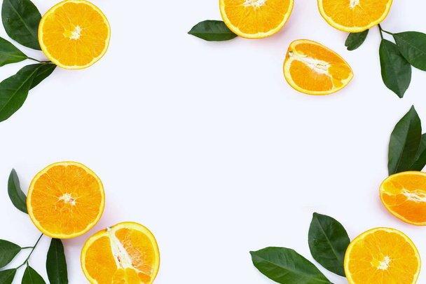 Telaio realizzato in frutta arancione con foglie verdi su sfondo bianco. - Foto, immagini