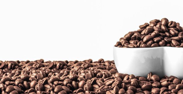 Grains de café en forme de coeur blanc plaque sur les grains de café frais Arrière-plan avec espace de copie. Photo de haute qualité - Photo, image