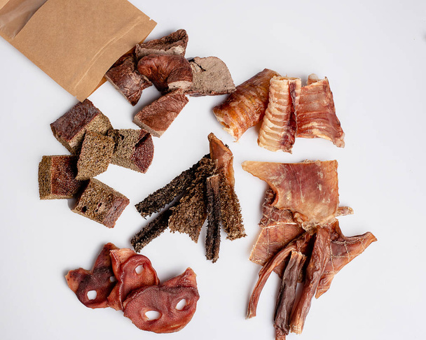 Natural dried treats for dogs. Treats for rewarding and training dogs. Dried meat products for dogs. Animal care.Selective focus. Advertisement for dog treats. Assorted snacks and treats for dogs. - 写真・画像