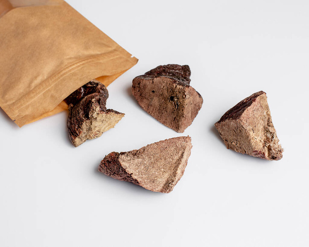 Natural dried treats for dogs. Treats for rewarding and training dogs. Dried meat products for dogs. Animal care.Selective focus. Advertisement for dog treats. beef lung. - Photo, image