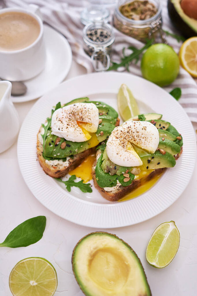 Freshly made poached egg and Avocado toasts on light grey background. - Photo, image