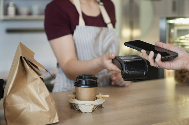 Unrecognizable client doing contactless payment in the cafe - Photo, Image