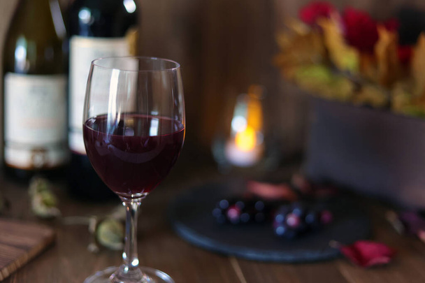 Ανάψτε ένα κερί και πιείτε κρασί σε μια ήρεμη ατμόσφαιρα - Φωτογραφία, εικόνα