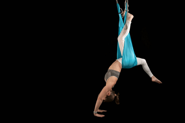 Sport woman practices inversion anti-gravity yoga positions. Fly yoga. Aerial gymnastics. Copy space - Foto, Imagem