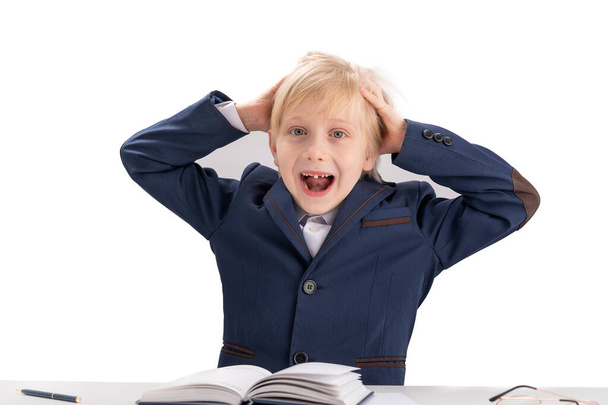 Boy doing homework. Schoolboy grabbing head and screaming. Overloaded child. Portrait isolated on white background - Foto, Imagem