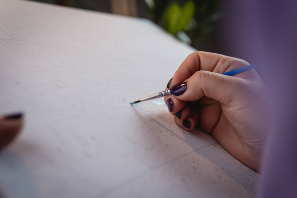 Η ενήλικη γυναίκα ζωγραφική με αριθμούς, παστέλ χρώματα, σχέδιο σε καμβά. Έννοιες της δραστηριότητας αναψυχής, χόμπι και να χαλαρώσετε - Φωτογραφία, εικόνα