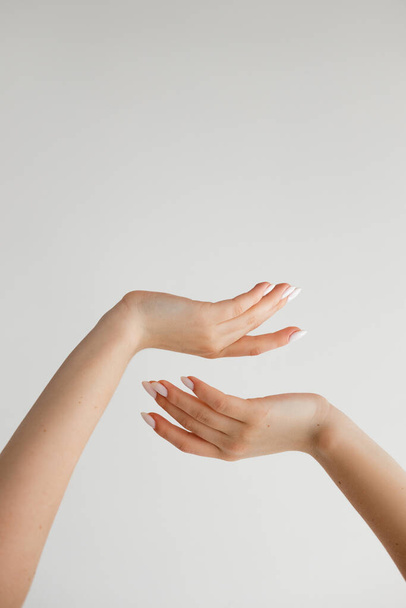 Hermosas manos femeninas sobre un fondo blanco. Foto de alta calidad - Foto, imagen