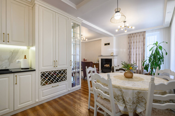 現代の古典的な大規模な白い色の豪華なキッチンとスタジオアパートのインテリアのダイニングルーム - 写真・画像