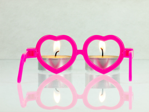 rosafarbene Gläser in Form von Herzen und Feuer. - Foto, Bild