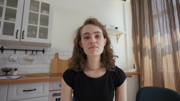 Cheerful woman talks to relative on video call distracted by boyfriend. Man comes into kitchen to hug girlfriend closeup from POV to third party - Imágenes, Vídeo
