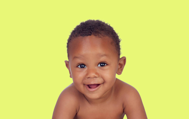 Portrait of a happy African baby isolated on a yellow background - Foto, afbeelding