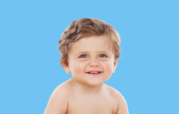 Portrait of a smiling happy baby boy isolated on blue background  - 写真・画像
