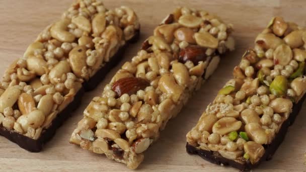 Granen superfood energierepen met amandel noten, droog fruit, rozijnen chocolade op de houten tafel - Video