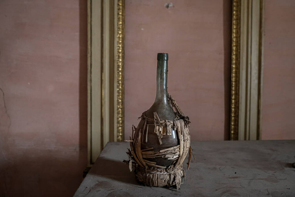 frasco de vino en la mesa en casa abandonada. Foto de alta calidad - Foto, imagen