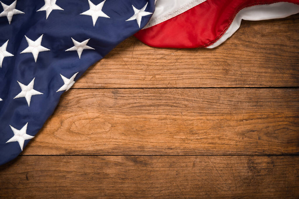 Плоский флаг США на коричневой деревянной доске, винтажный фон с видом сверху на копировальное пространство. Знамя, минимализм, мансардный стиль. Американский - Фото, изображение