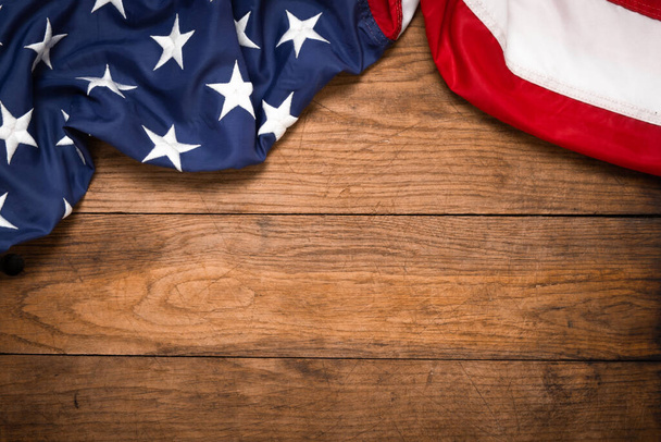 Płaska flaga USA na brązowej drewnianej desce, vintage tło z kopią przestrzeni widok z góry. Baner, minimalizm, styl poddasza. Stany Zjednoczone - Zdjęcie, obraz