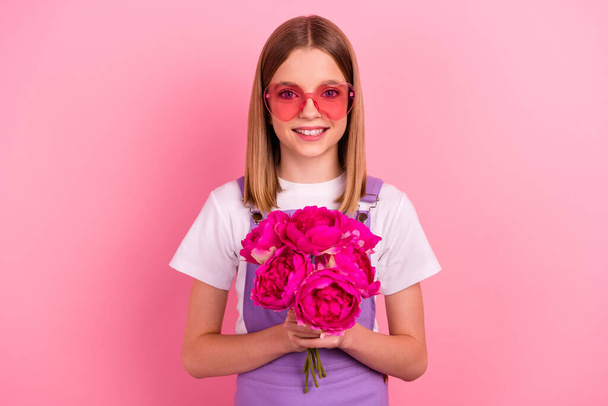 Photo of charming girl daughter give present bouquet of flowers to her mother isolated on pink color background. - Фото, зображення