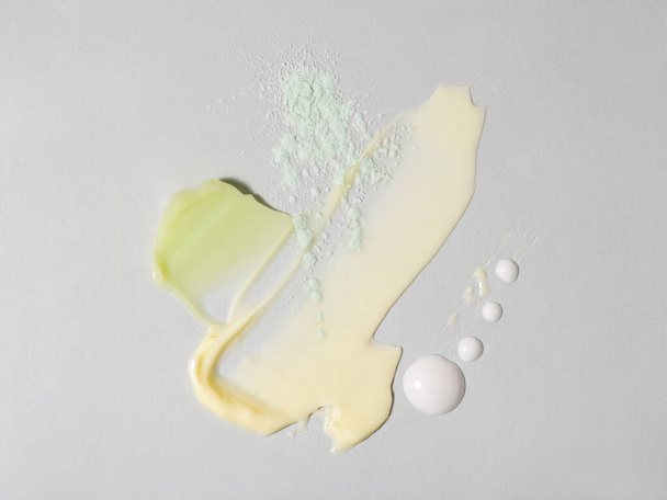 Various color face cream swatches on elegant grey background. Cream and powder textures. A sample of cosmetics for magazine or brochure design. Skin care and daily beauty routine concept. - Zdjęcie, obraz