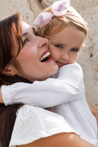 Портрет девочки, обнимающей улыбающуюся мать на открытом воздухе в Валенсии - Фото, изображение