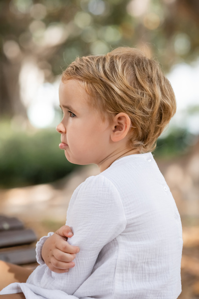 Side view of upset baby girl looking away outdoors  - Foto, immagini