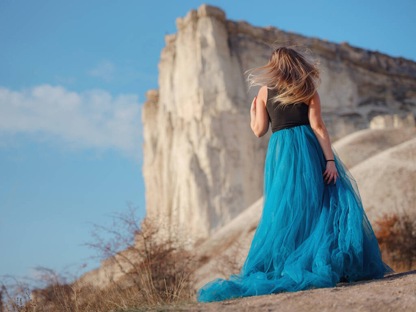 Mulher na moda no campo do deserto perto da montanha usando top preto e saia de tule azul. Oeste selvagem. Férias de verão dança. Modelo bonito e sexy plus size - Foto, Imagem